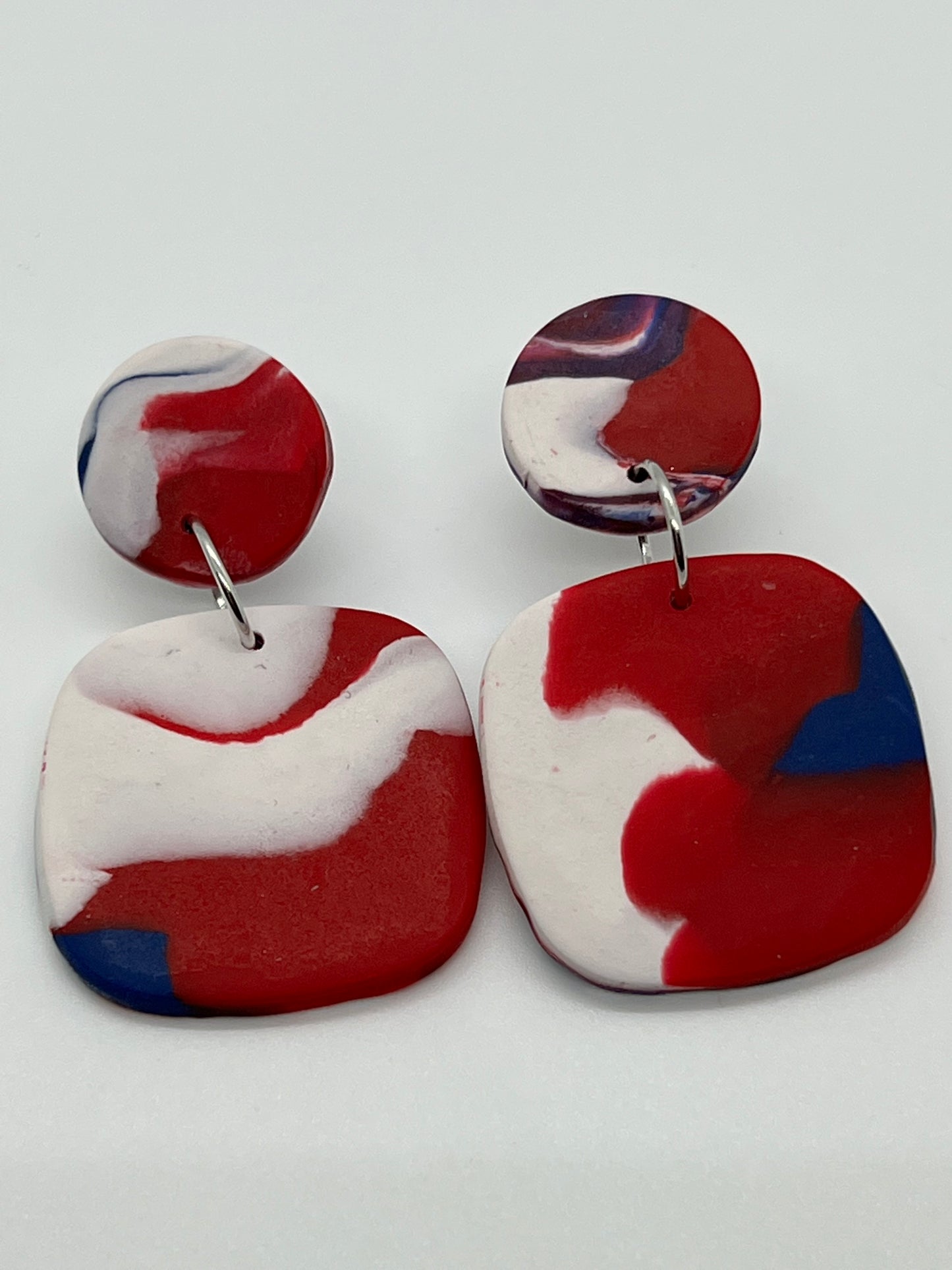 POLYMER SQUARE WITH CIRCLE POST IN SWIRLS OF RED, WHITE & BLUE